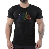 Male model wearing a fitted black t-shirt featuring a rainbow rhinestone Boystown Chicago skyline graphic inspired by LGBTQ Pride, Chicago nightlife, disco culture, and gay fashion by Rico Starr