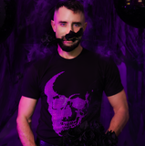A man wearing a black t-shirt with a neon purple rhinestone skull graphic by Rico Starr