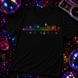 A black short-sleeve t-shirt featuring a colorful rainbow skyline of Las Vegas with the text 'LAS VEGAS' underneath by Rico Starr