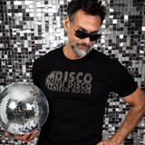 Male model wearing a fitted black rhinestone “Disco Nu Disco Disco House” t-shirt while holding a disco ball in front of a mirrored disco tile backdrop by Rico Starr