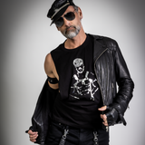 Male model wearing a black leather-inspired shredder tank top with a metallic fetish graphic, styled with a biker cap, leather jacket, gloves, and sunglasses in an edgy gay club fashion look by Rico Starr