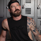 Man wearing a black deep armhole tank top featuring a black rhinestone XXX graphic. Bold LGBTQ+ nightlife fashion with a sleek monochromatic design, modern athletic fit, and sexy clubwear styling for gay men, Pride events, parties, festivals, and nightlife culture by Rico Starr