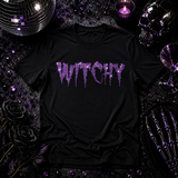 Black t-shirt with purple glitter "Witchy" text in a dripping, spooky font design by Rico Starr