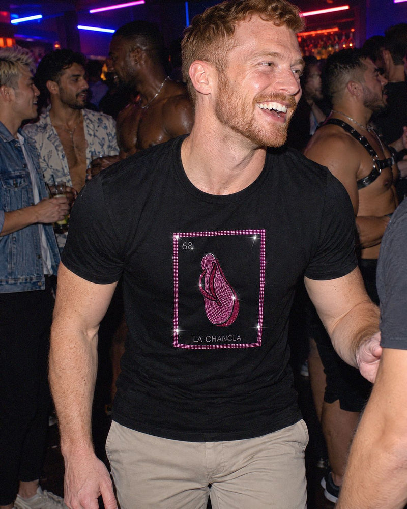 A man at a party wearing the La Chancla shirt